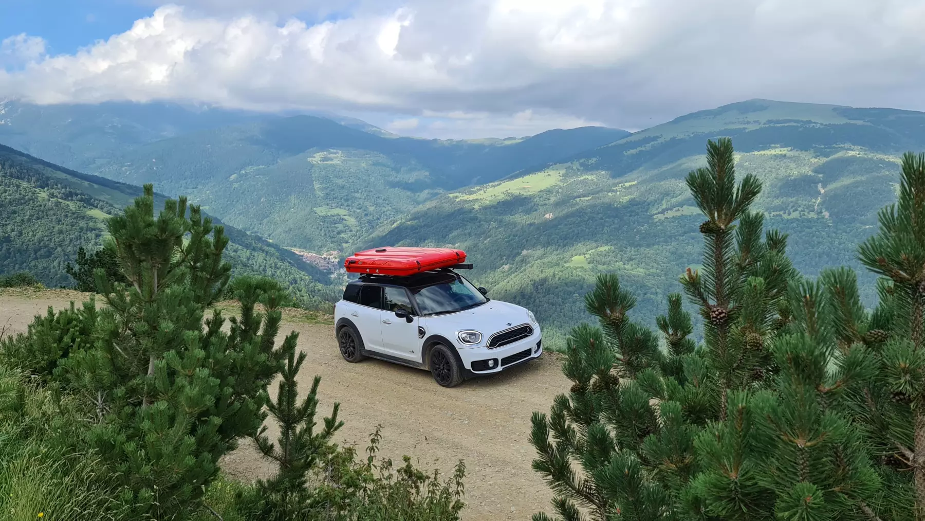 Dream Fontanilles red Evasion rooftop tent on top of a white Mini Cooper